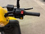 a close up of the handlebars on a yellow motorcycle