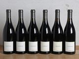 six bouteilles de vin sont alignées sur une table en bois