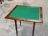 a small table with a green top sitting on a cement floor