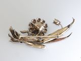 a silver brooch with flowers on it on a table