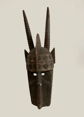 an image of a wooden mask with horns on a white background