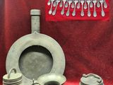 many different types of pottery on display on a red cloth