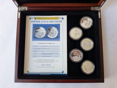 a wooden box with four coins in it and a certificate