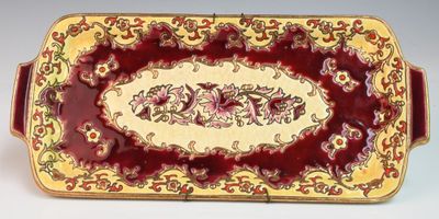 un gros plan d'une assiette rouge et dorée ornée d'un motif floral