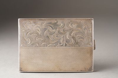 an antique silver cigarette case with a floral design on the front