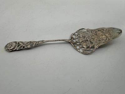 a silver spoon with a floral design on it