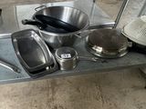 many pots and pans sitting on a metal shelf
