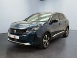 Une voiture bleue est garée dans une pièce au sol noir.
