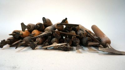 a pile of root vegetables on a table with a pair of pliers
