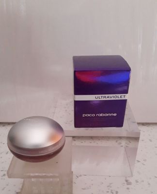 un flacon de parfum posé sur une table, à côté d'une boîte de parfum