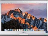 an apple macbook air laptop computer with a mountain in the background