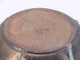 a close up of a metal bowl on a white surface