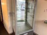 une vitrine en verre dans le coin d'une pièce