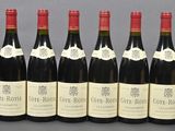 six bottles of wine are lined up on a table