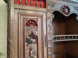 a wooden cabinet with carvings on it in a room