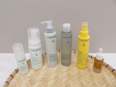 bottles of skin care products sitting on a bamboo tray on a table