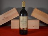 a bottle of wine sitting on a table next to two wooden boxes