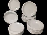 Plusieurs assiettes blanches sont empilées les unes sur les autres sur un fond noir.