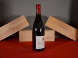 a bottle of wine sitting on a table next to two wooden boxes