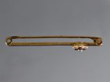a close up of a gold pin with a diamond on it