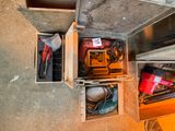 de nombreux outils qui se trouvent dans une boîte posée par terre