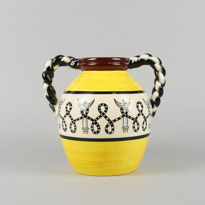 a yellow vase with black and white designs on it