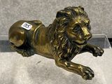 une statue représentant un lion couché par terre