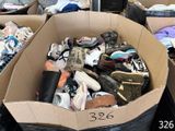 une boîte remplie de chaussures qui traîne dans une pièce