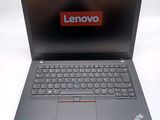 the laptop is open on a white surface with a red lenovo logo on the screen