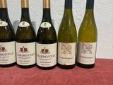 six bottles of wine are lined up on a table