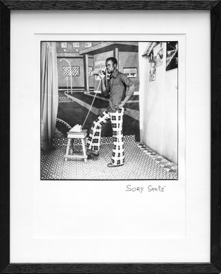 black and white photograph of a man sitting on a chair in a room