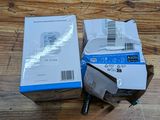two boxes of electronic devices sitting on top of a wooden table