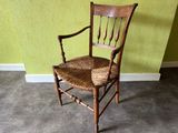 a wooden chair with a wicker seat in a room