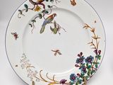 a plate with birds and flowers on it on a table