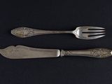two forks and a spoon on a black table