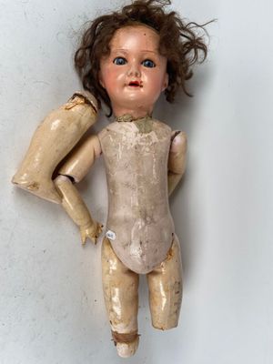a doll that is standing on a white surface