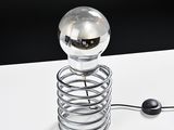 a glass ball that is sitting on top of a metal coil