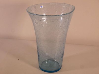 un vase en verre bleu posé sur une surface blanche