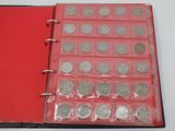 a red book with a bunch of silver coins in it