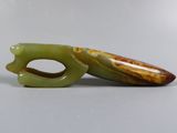 two pieces of green jade sitting on a table