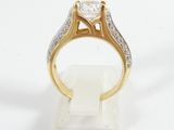 a close up of a gold and diamond ring on a white surface