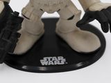 a toy figure of a star wars character holding a gun