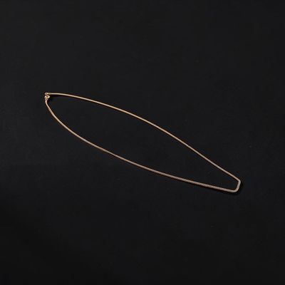 a gold plated hair pin on a black background