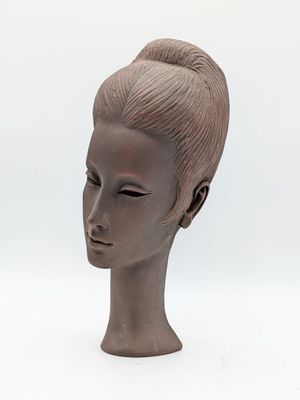 sculpture représentant la tête d'une femme sur fond blanc