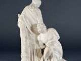 an old statue of a woman kneeling down with a dog