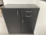 black cabinet with two drawers and a door in a room
