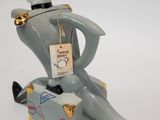 a figurine of a man sitting on top of a suitcase