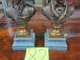 deux bustes en bronze représentant deux hommes assis sur une table
