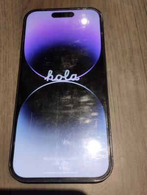 un gros plan d'un téléphone portable posé sur une table en bois