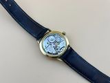 un gros plan d'une montre avec un bracelet bleu posée sur une table